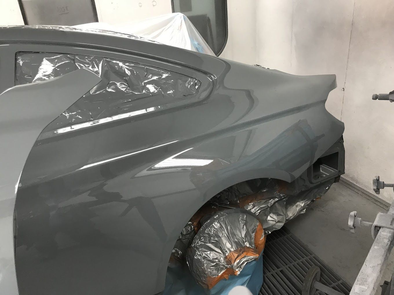 A car is being painted in a paint booth.