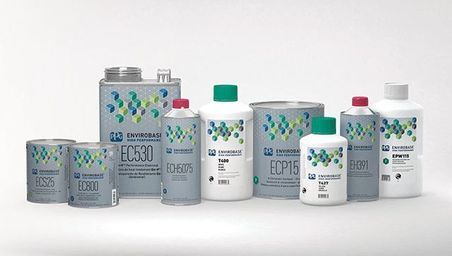 A group of bottles of paint are lined up on a table.
