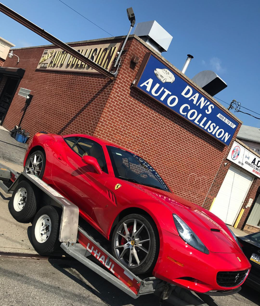 A red sports car is being towed to dan 's auto collision