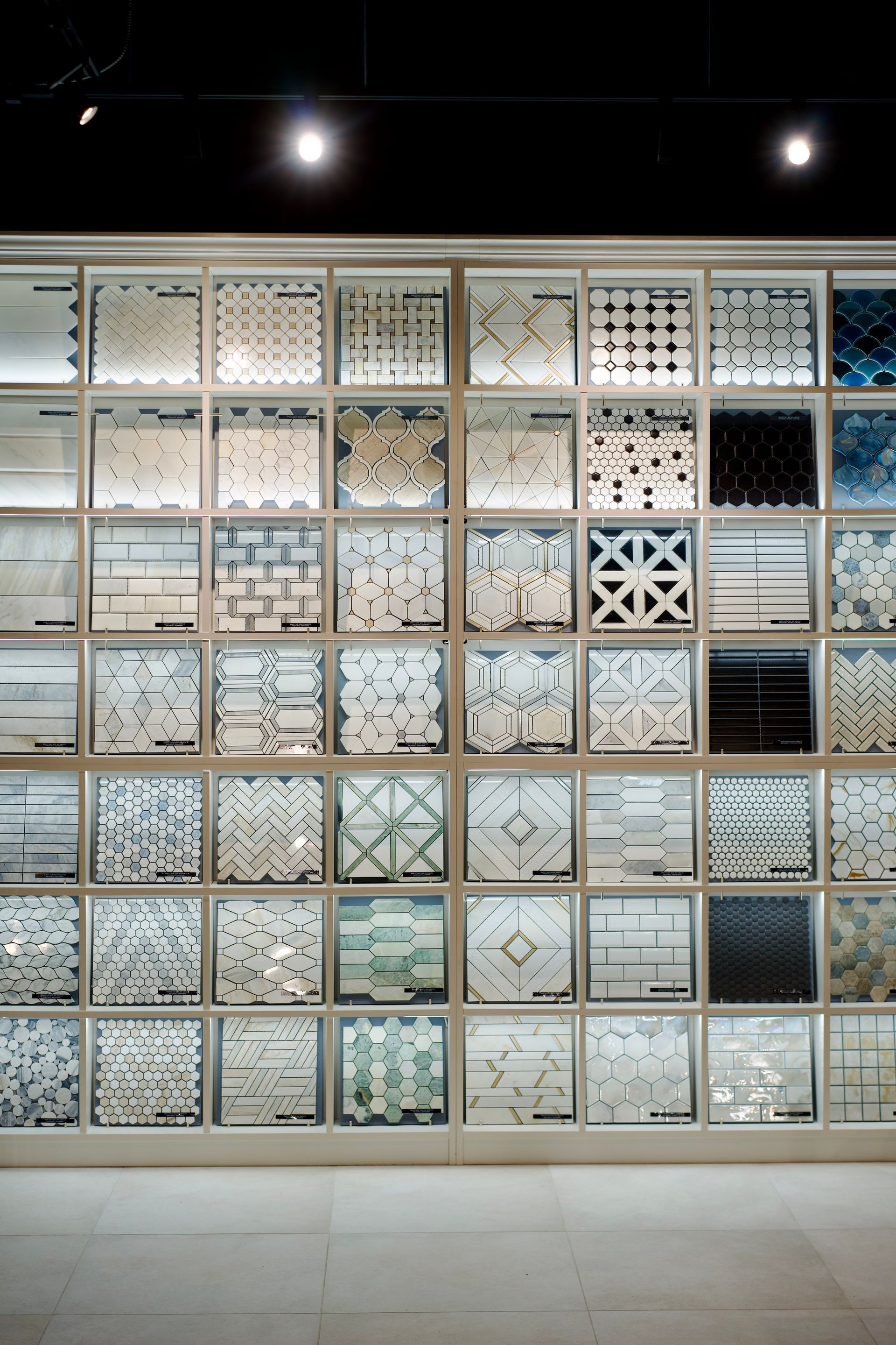 Mur décoratif de carreaux blancs à motifs assortis dans une galerie intérieure éclairée
