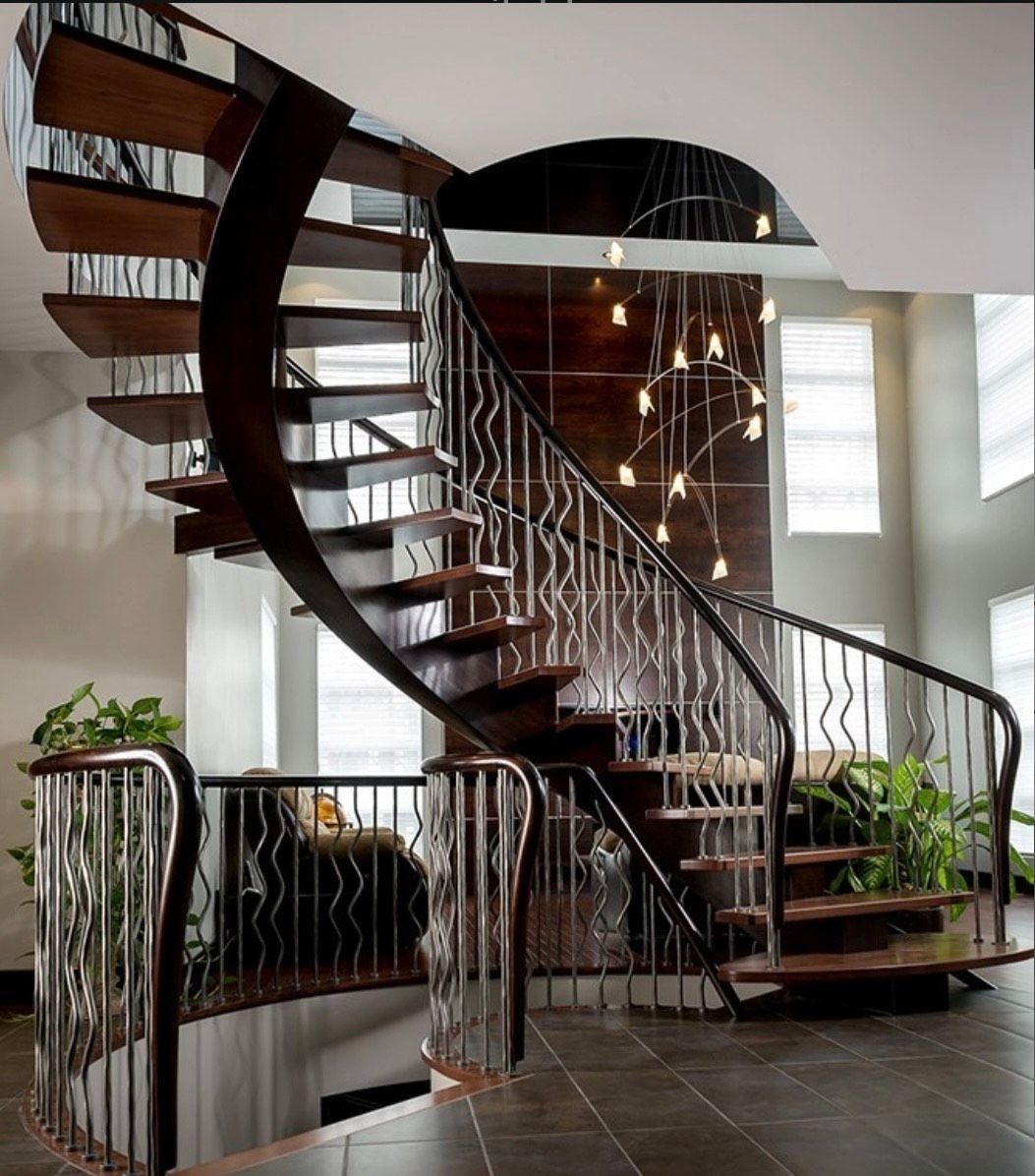 Escalier en bois courbé avec rampe en métal dans un intérieur de maison moderne