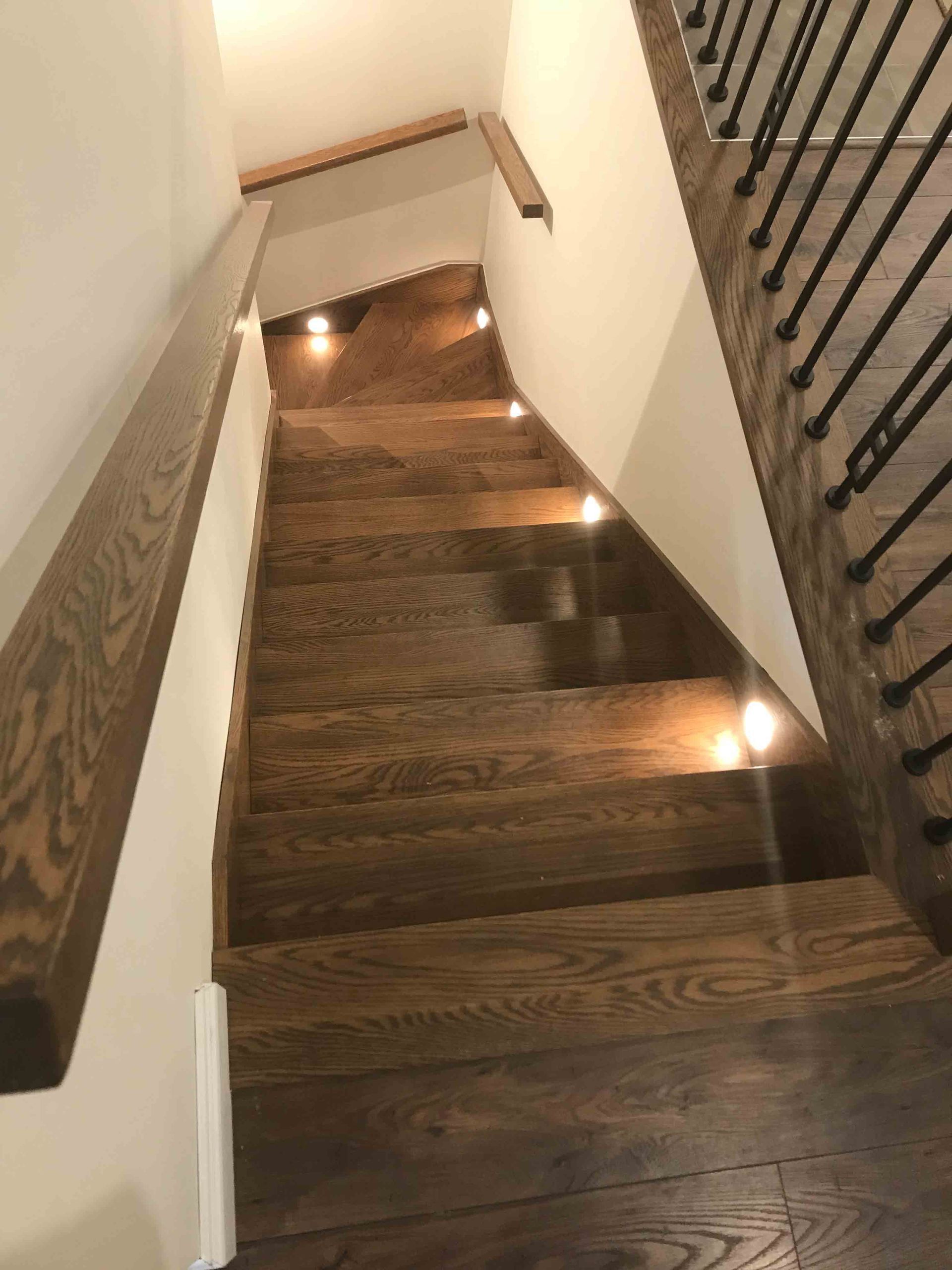 Un escalier moderne avec une rampe en verre dans un salon