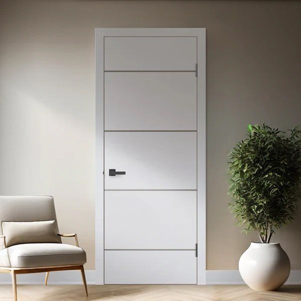 A living room with a white door , chair , and potted plant.