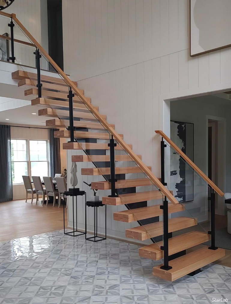 A wooden staircase with a glass railing in a house