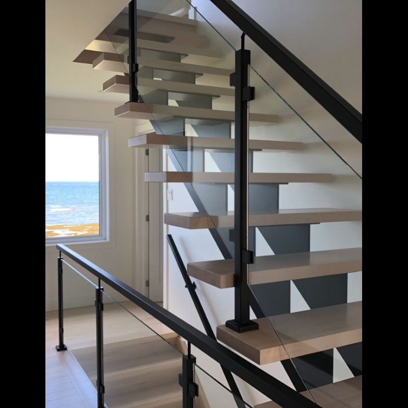 A staircase with a glass railing and a view of the ocean