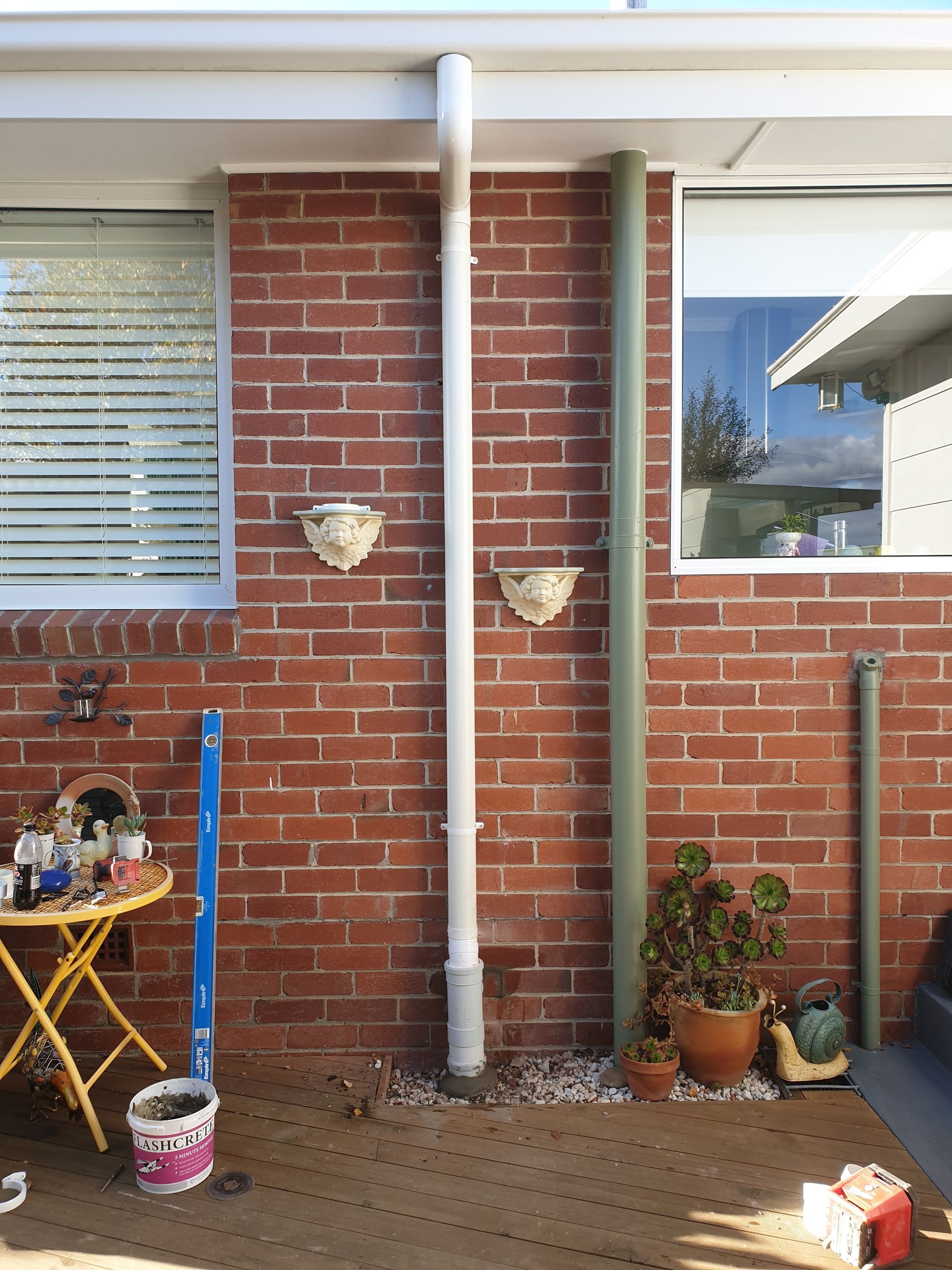 A Blue Metal Shed With a White Gutter and a Large Water Tank — Lenny's Plumbing & Contracting in Granton, TAS