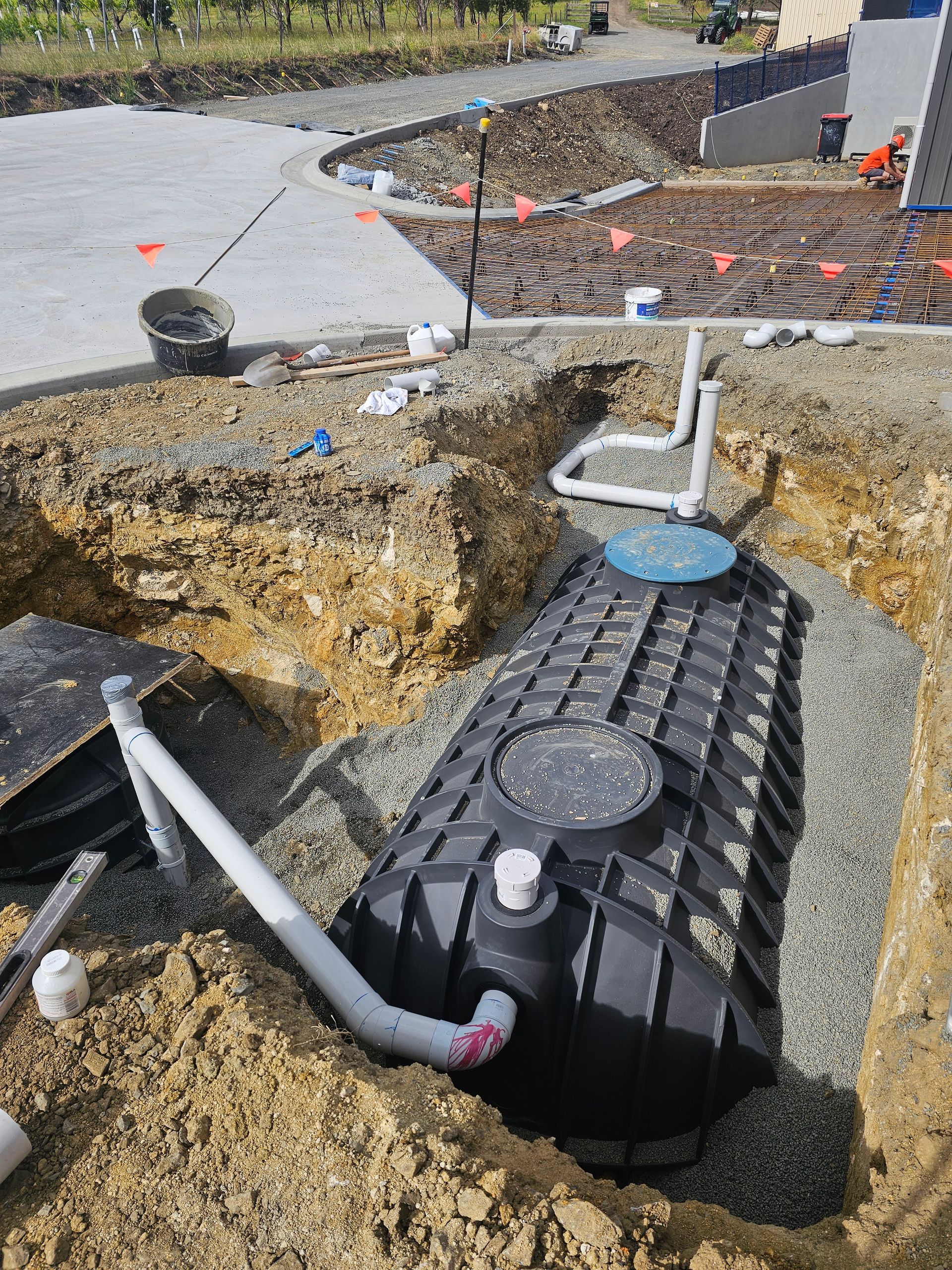 Two Black Plastic Septic Tanks With Green Lids Installed — Lenny's Plumbing & Contracting in Granton, TAS