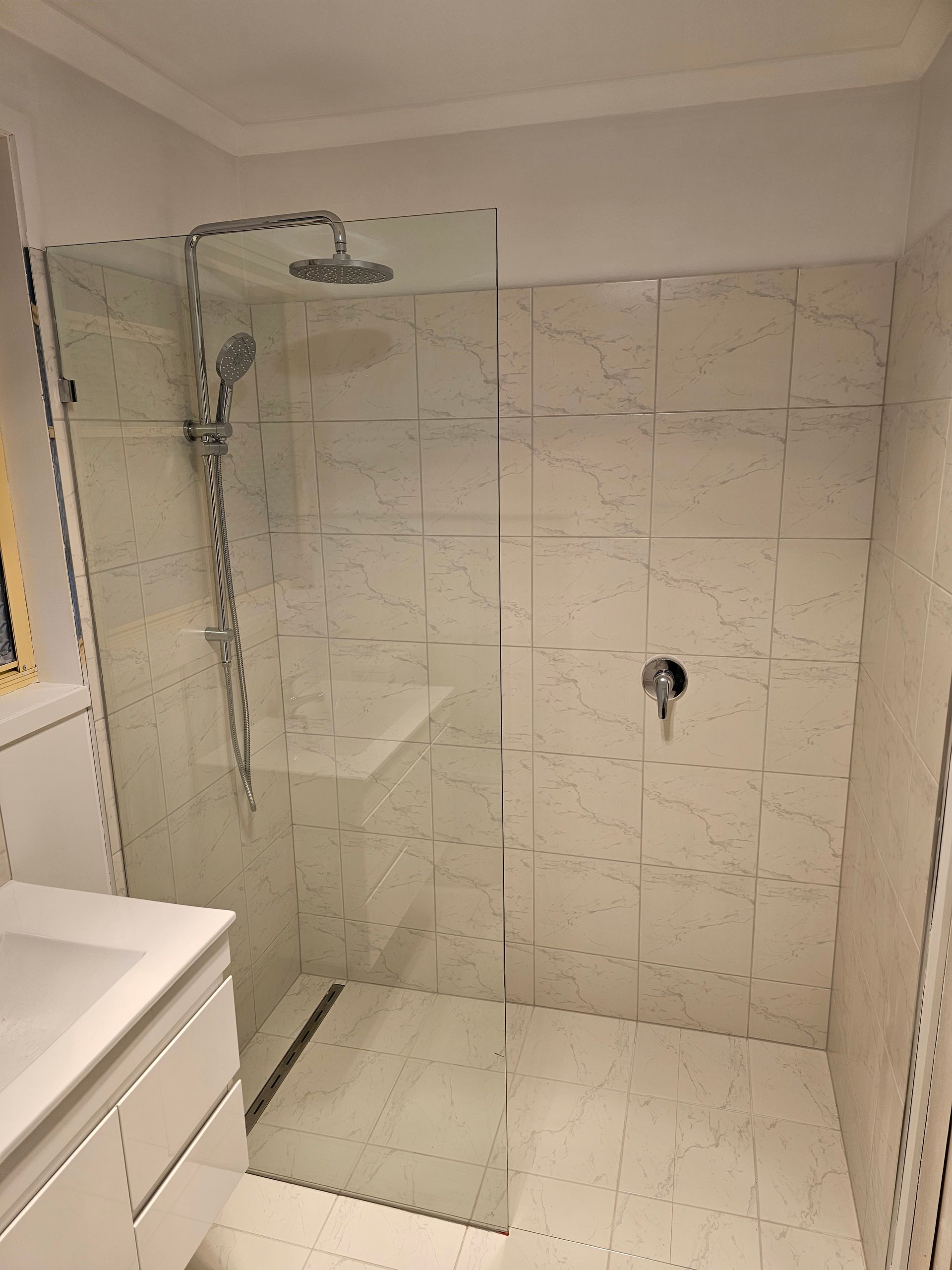 A walk-in shower with a glass panel — Lenny's Plumbing & Contracting in Granton, TAS
