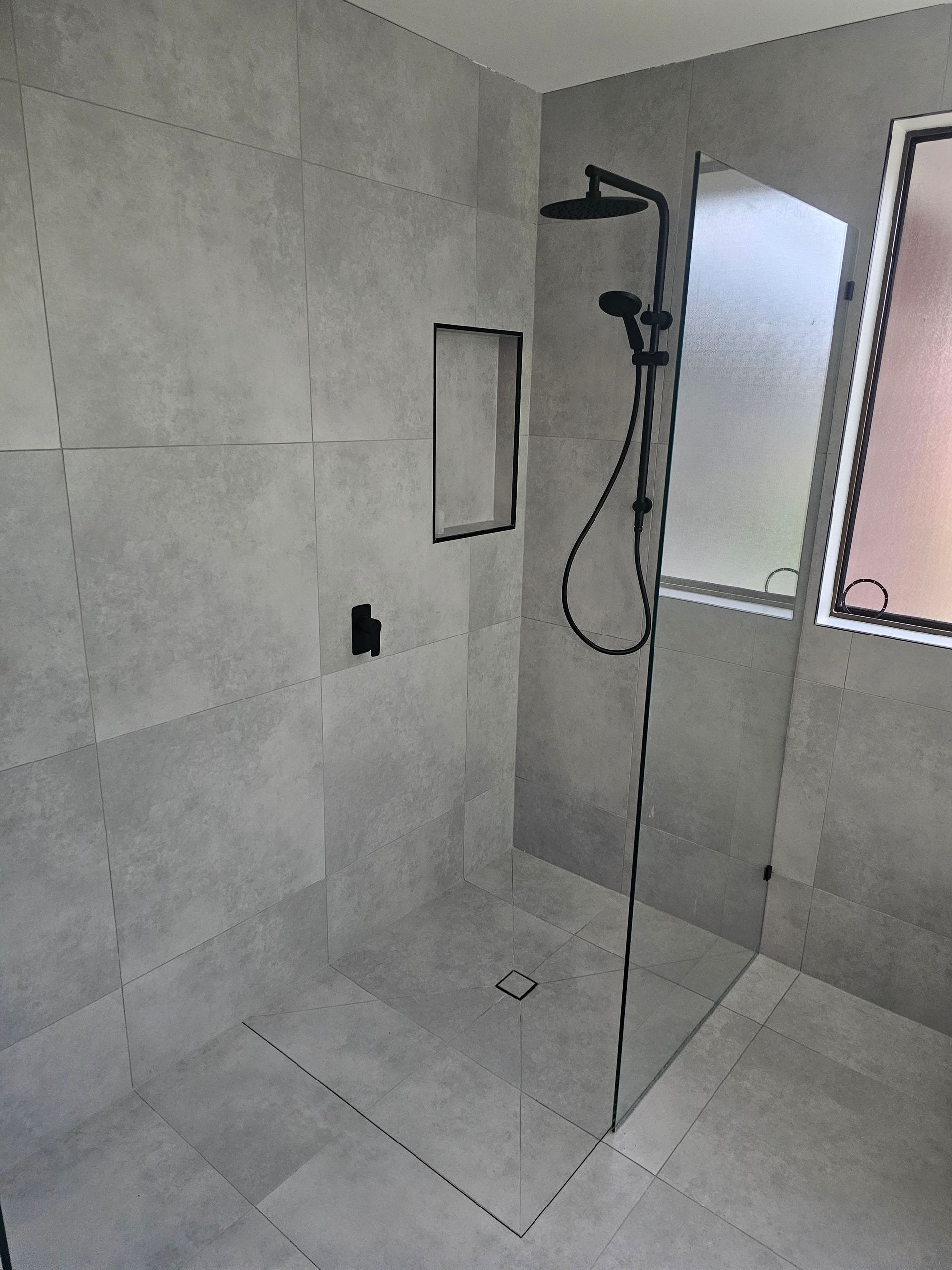 A modern walk-in shower with matte black fixtures — Lenny's Plumbing & Contracting in Granton, TAS