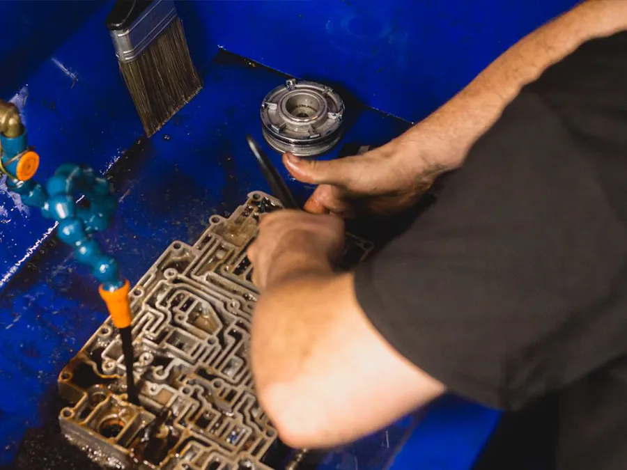 A man is working on a machine in a blue sink.