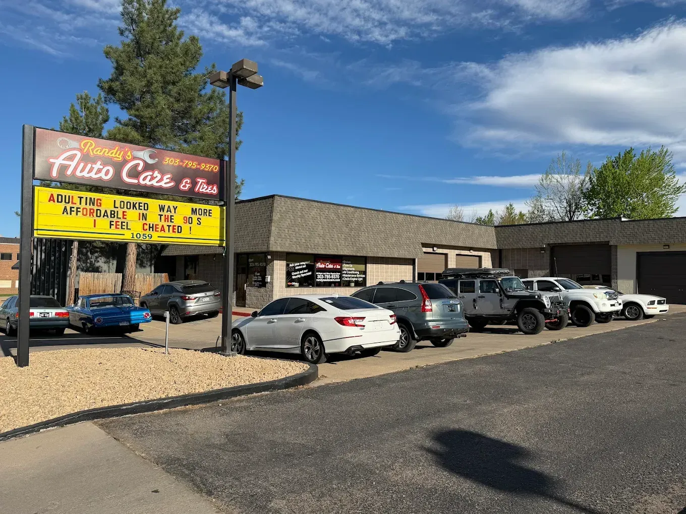 Palace Cafe sign beside a parking lot with several parked cars on a sunny day