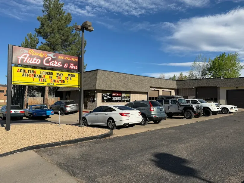 Palace Cafe sign beside a parking lot with several parked cars on a sunny day