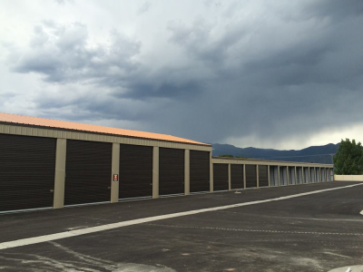 A row of storage units with a cloudy sky in the background