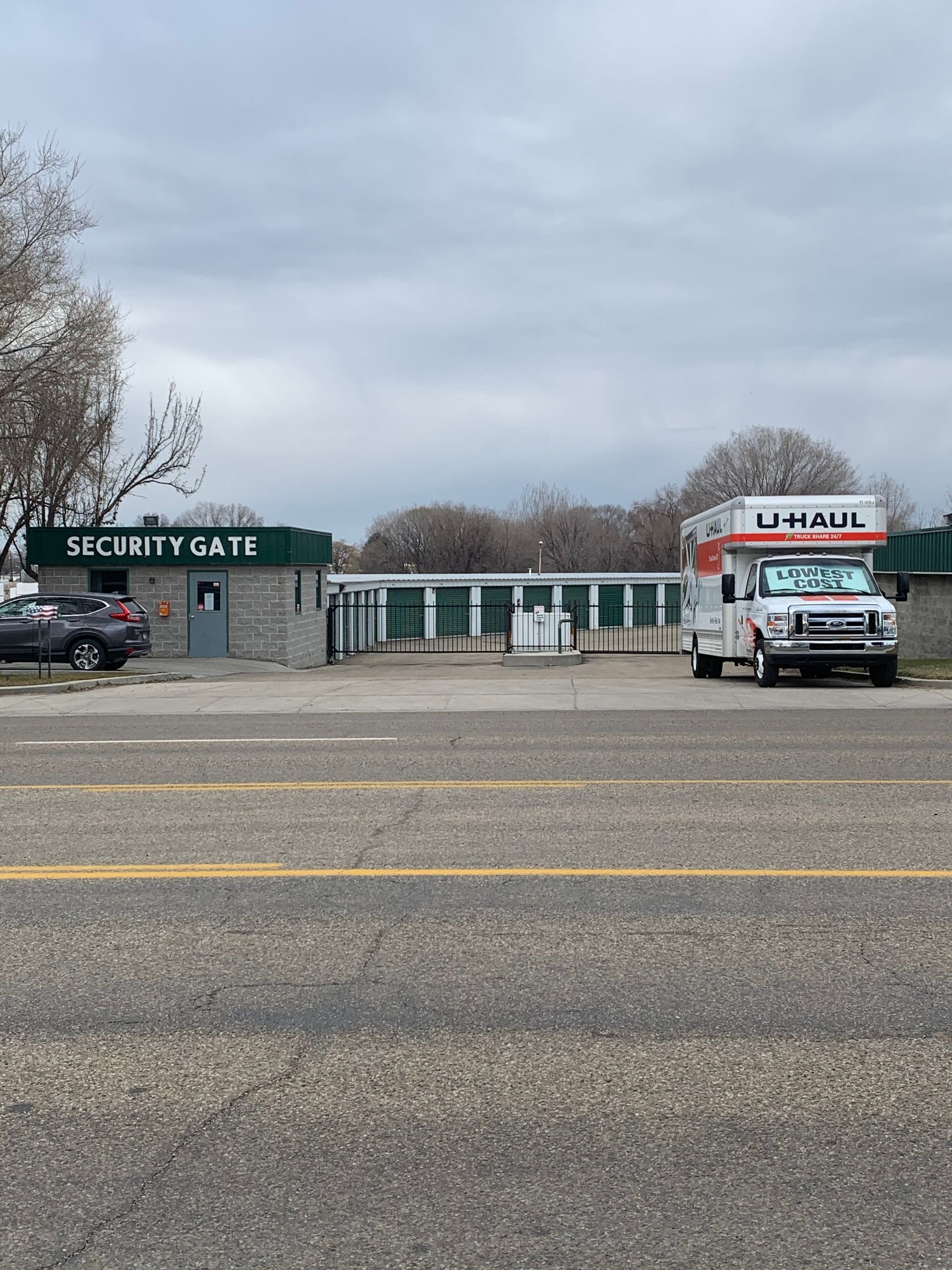 A white truck is parked in front of a security gate.
