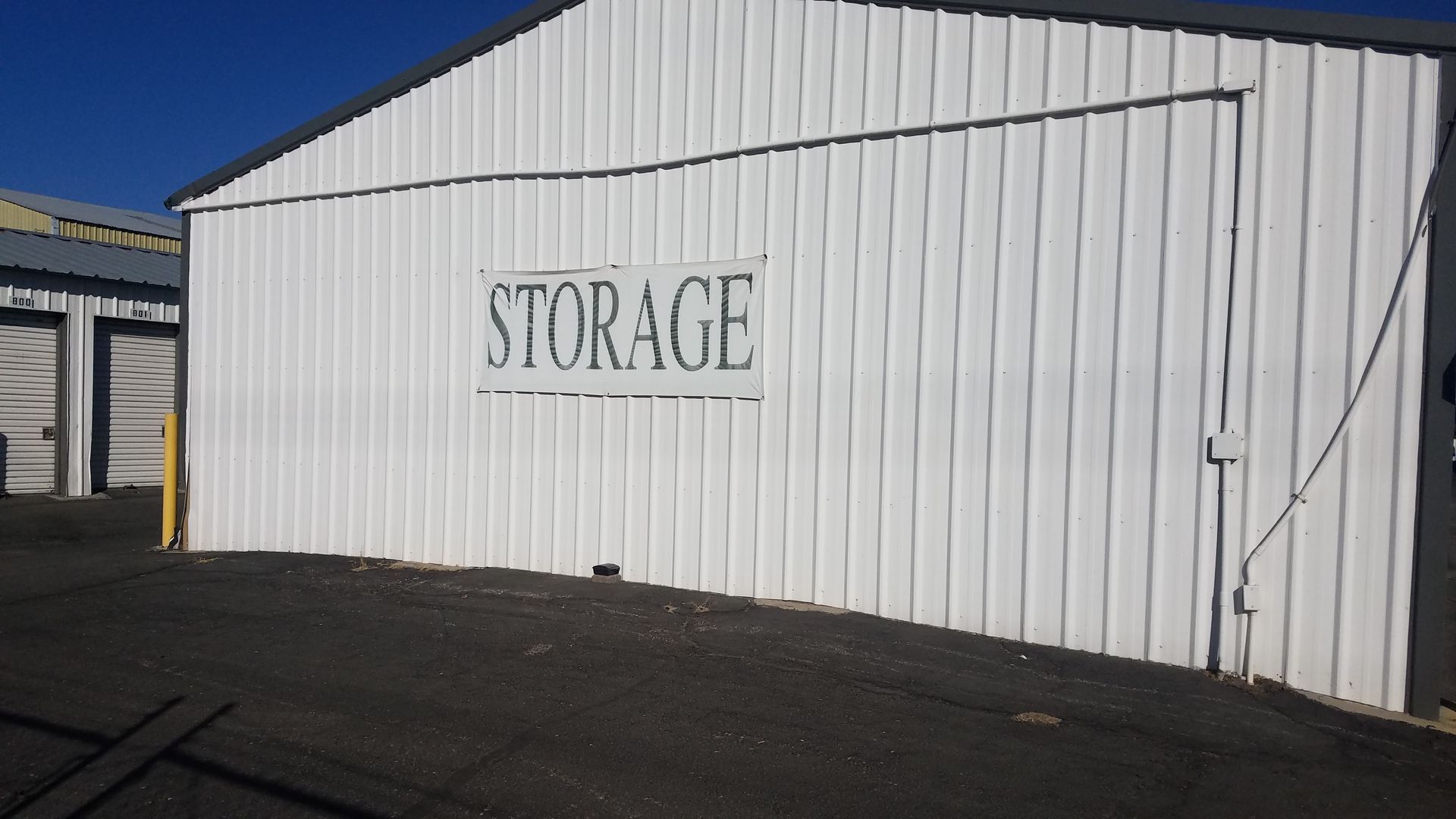 A white building with a sign that says storage on it
