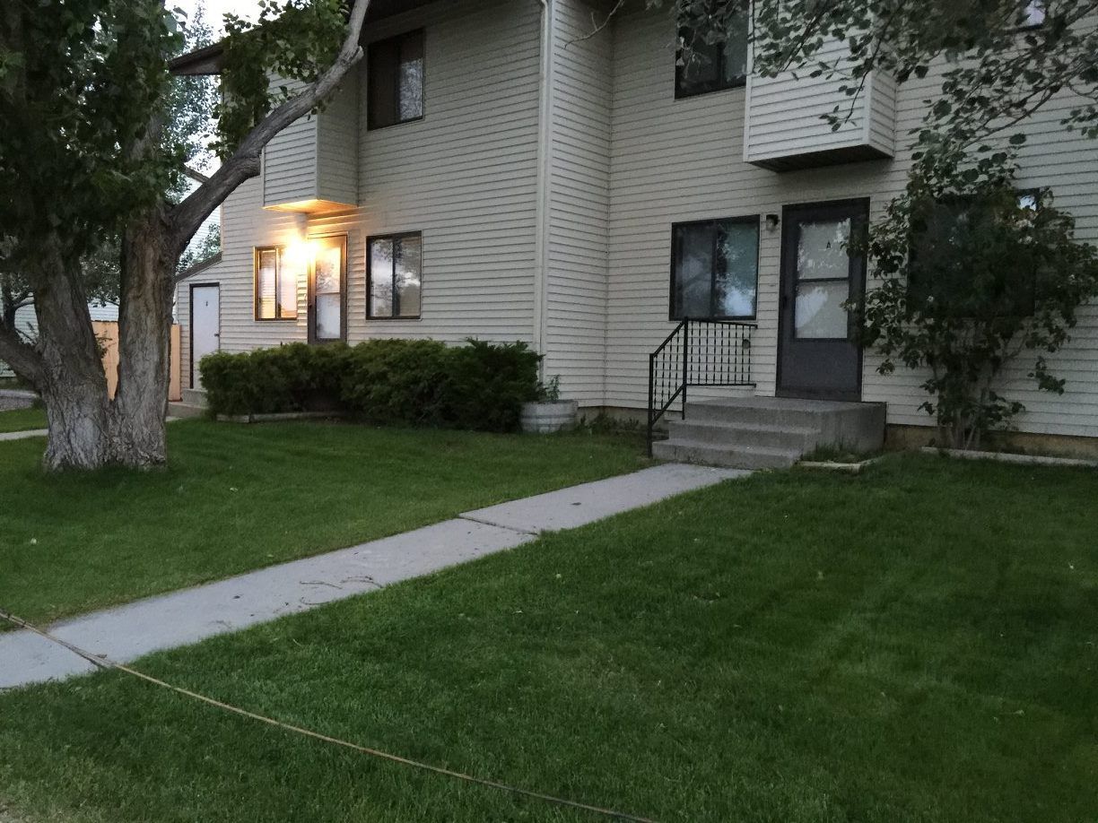 A house with a lush green lawn in front of it