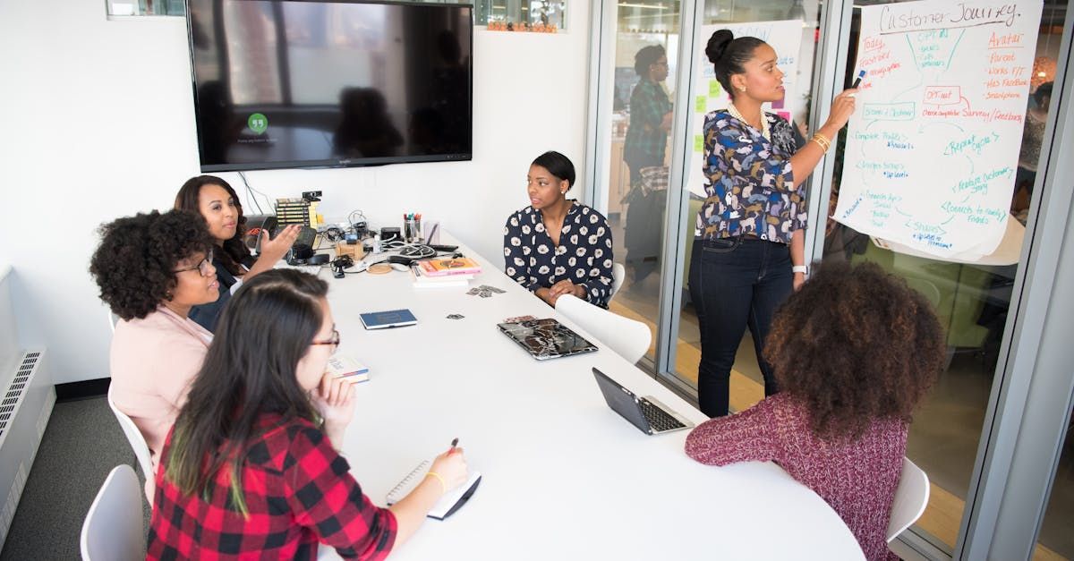 A group of women are sitting around a table in a conference room.