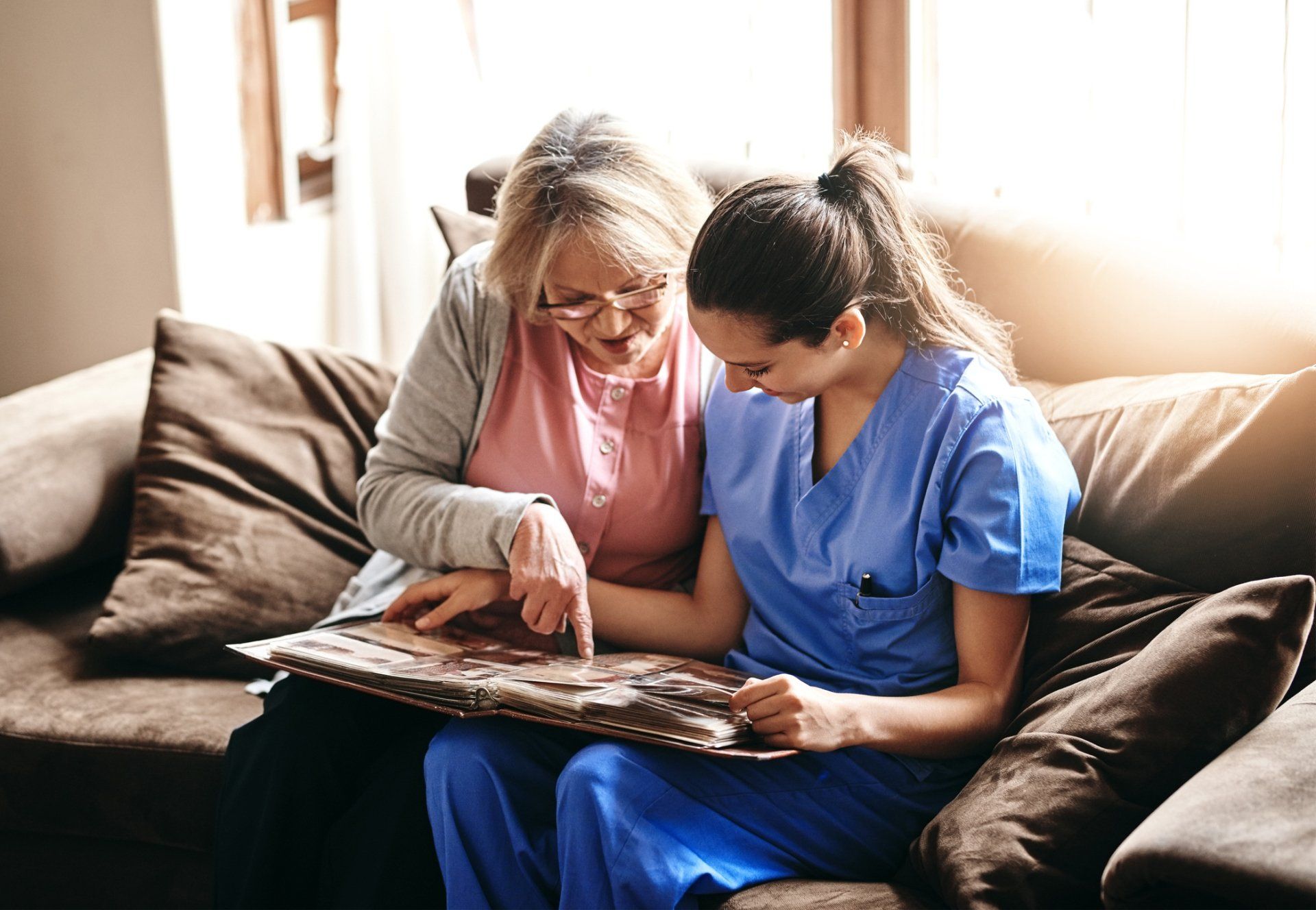 Nurse and a Senior Woman Looking at a Photo Album — Dallas, TX — Kristi’s Senior Solutions