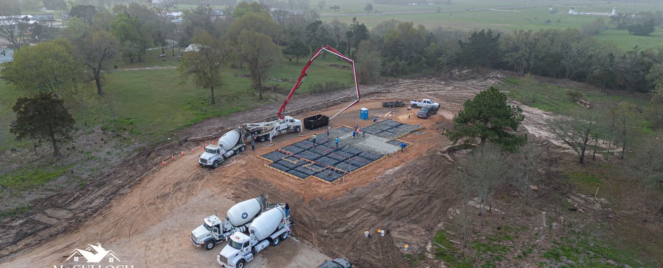 An aerial view of a construction site with trucks and a crane.