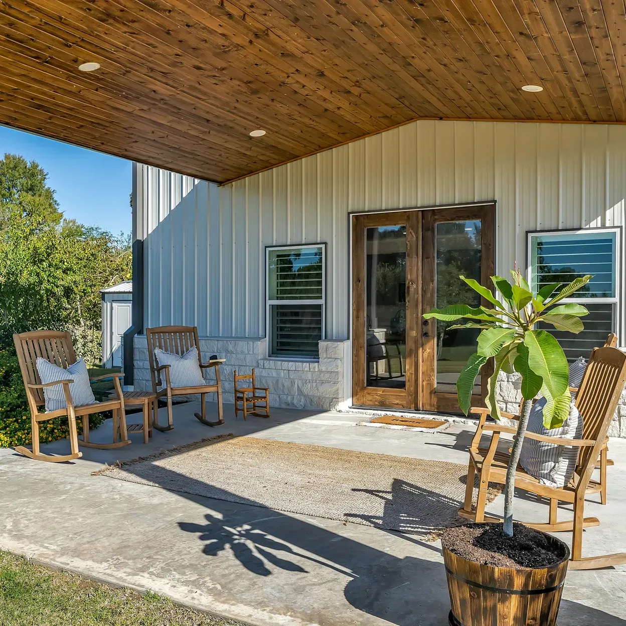 A porch with rocking chairs and a potted plant