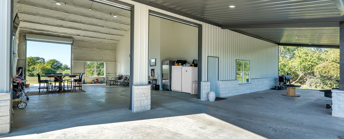 A large white building with a covered porch and sliding doors.