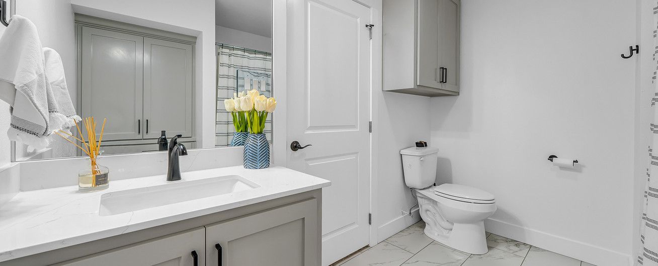 A bathroom with a sink , toilet , and mirror.