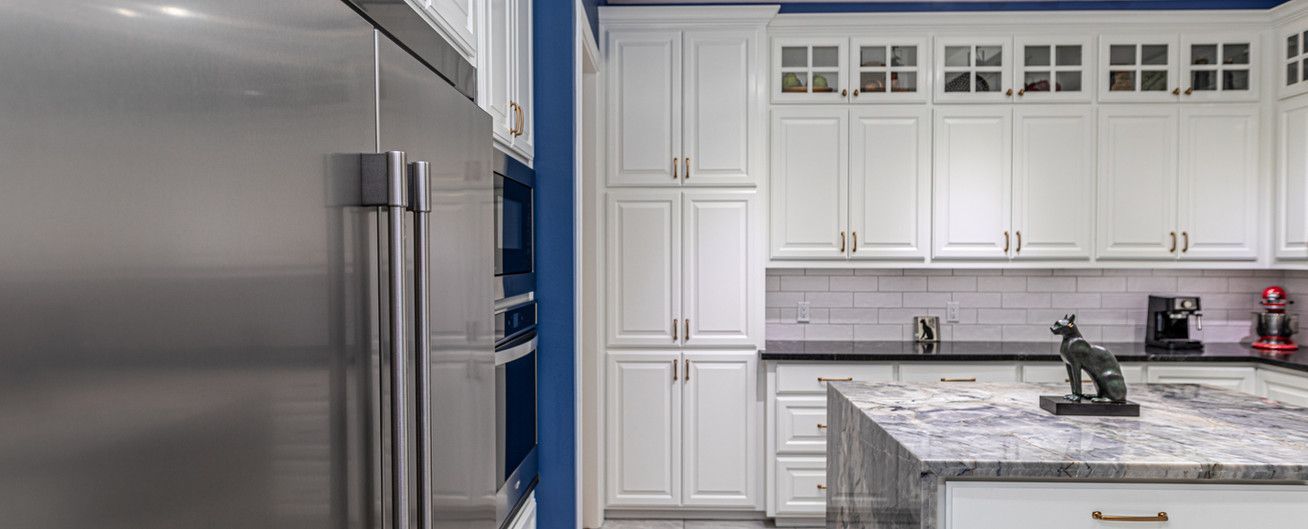 A kitchen with white cabinets and stainless steel appliances.