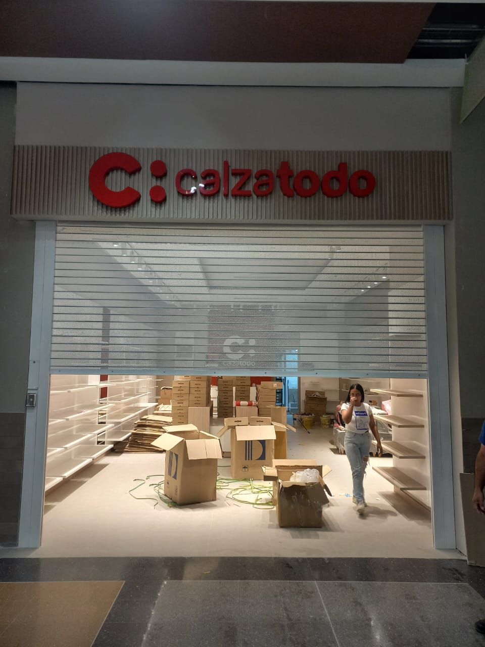 Tienda Calzedonia cerrada con cajas en el interior y un trabajador de pie cerca de la entrada.