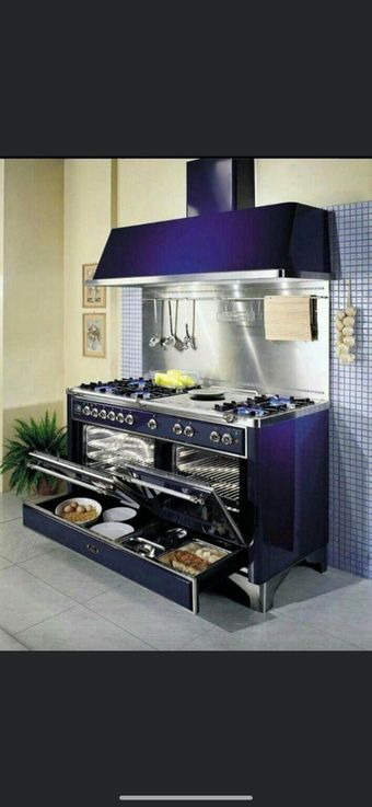 Modern stainless-steel outdoor kitchen with purple hood and cabinets on a patio
