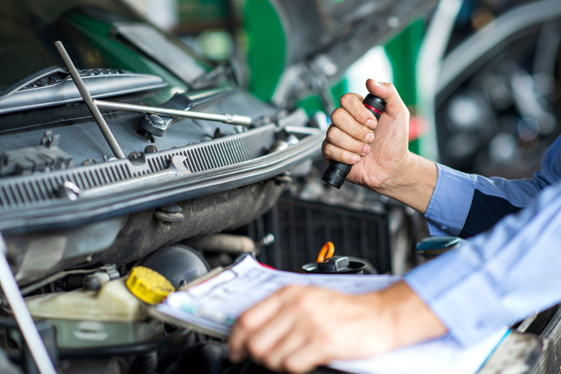 A mechanic is working on a car in a garage.