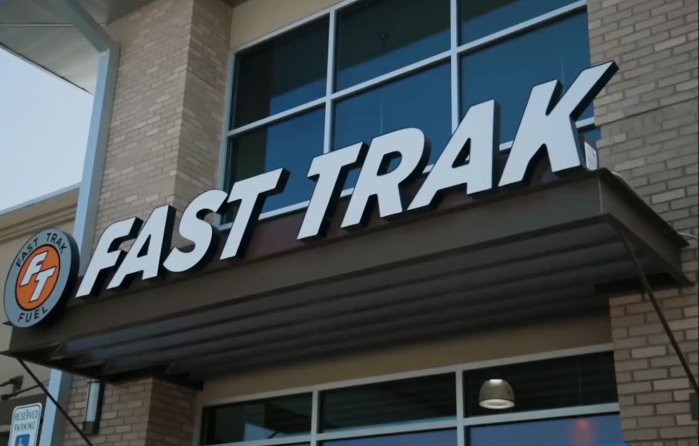 FAST-TRAK storefront sign on a brick building with blue window panes