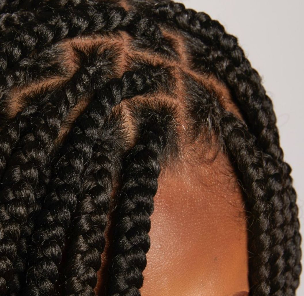 Close-up view of black hair styled in neat, square-parted box braids.