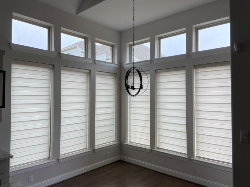 A corner of windows has white dual shades.