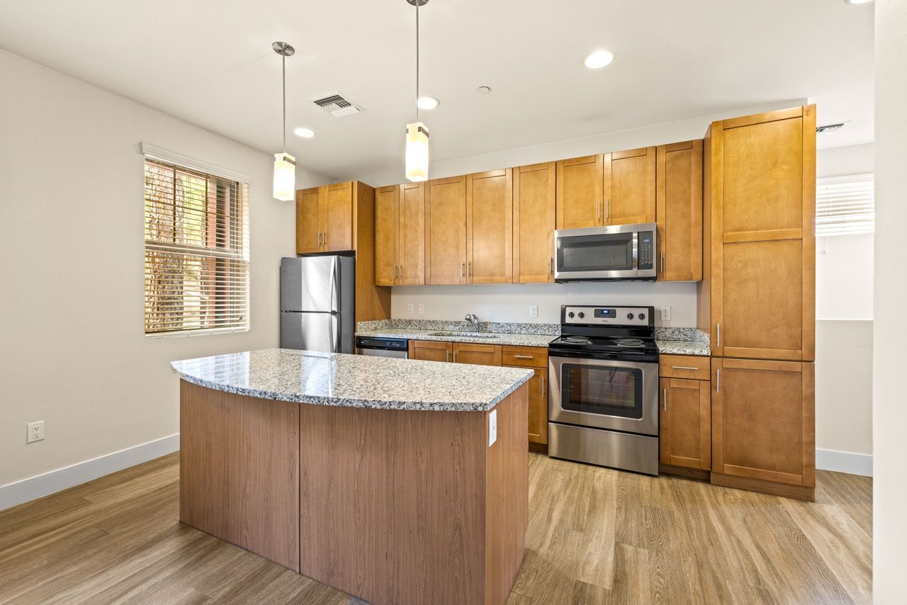 Kitchen in a modern apartment with granite countertops and stainless steel appliances.