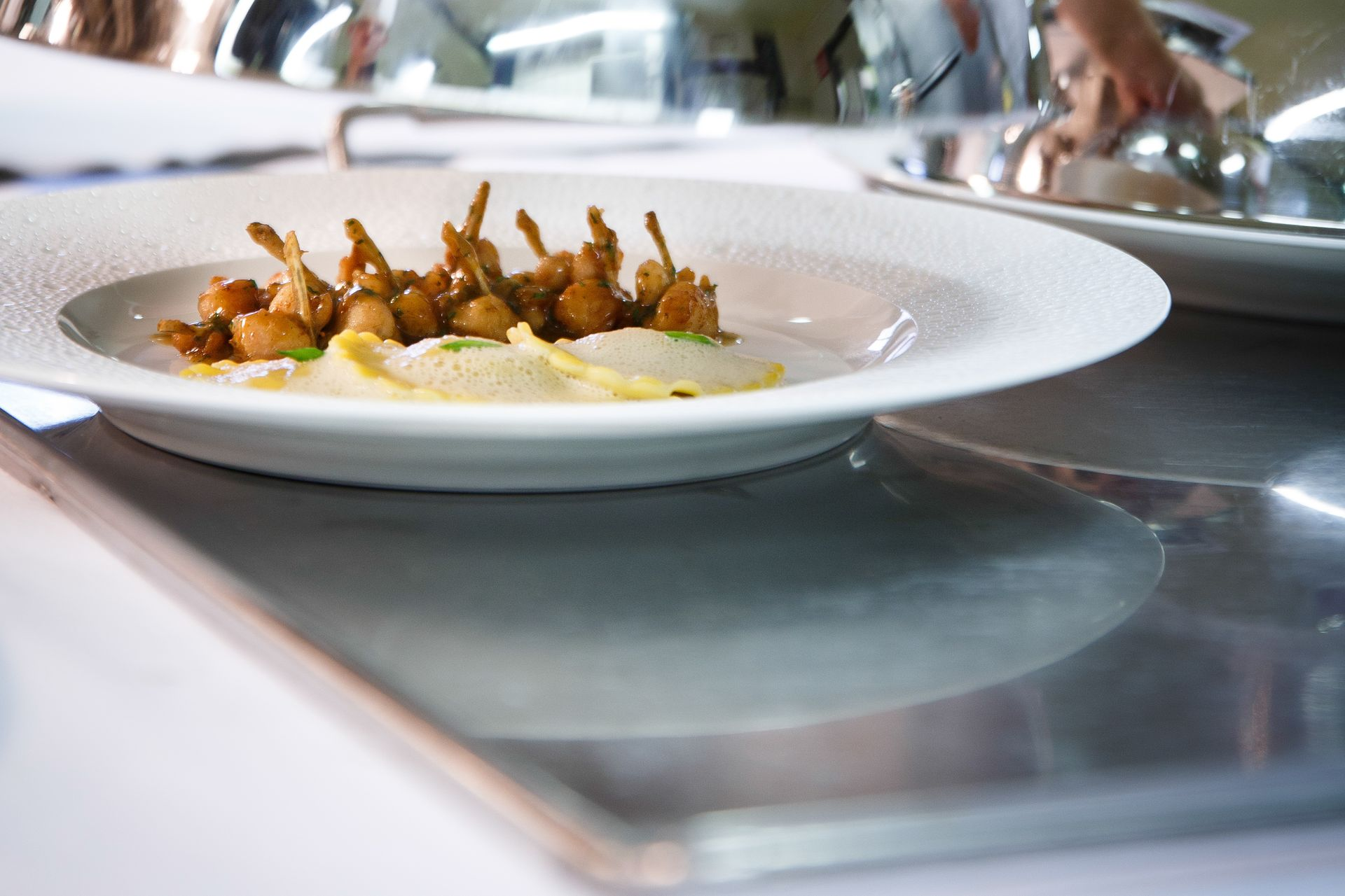 Une assiette blanche garnie de viande et de légumes sur une table verte.