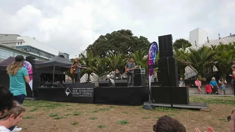 A group of people are standing in front of a stage at a concert.