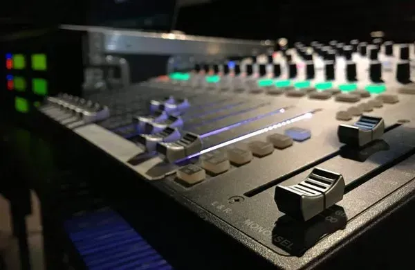 A close up of a mixer with a keyboard in the background.