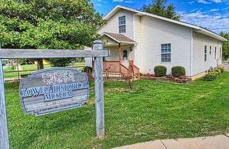 Town Hall Museum sign in front of a beige building with a porch and green lawn