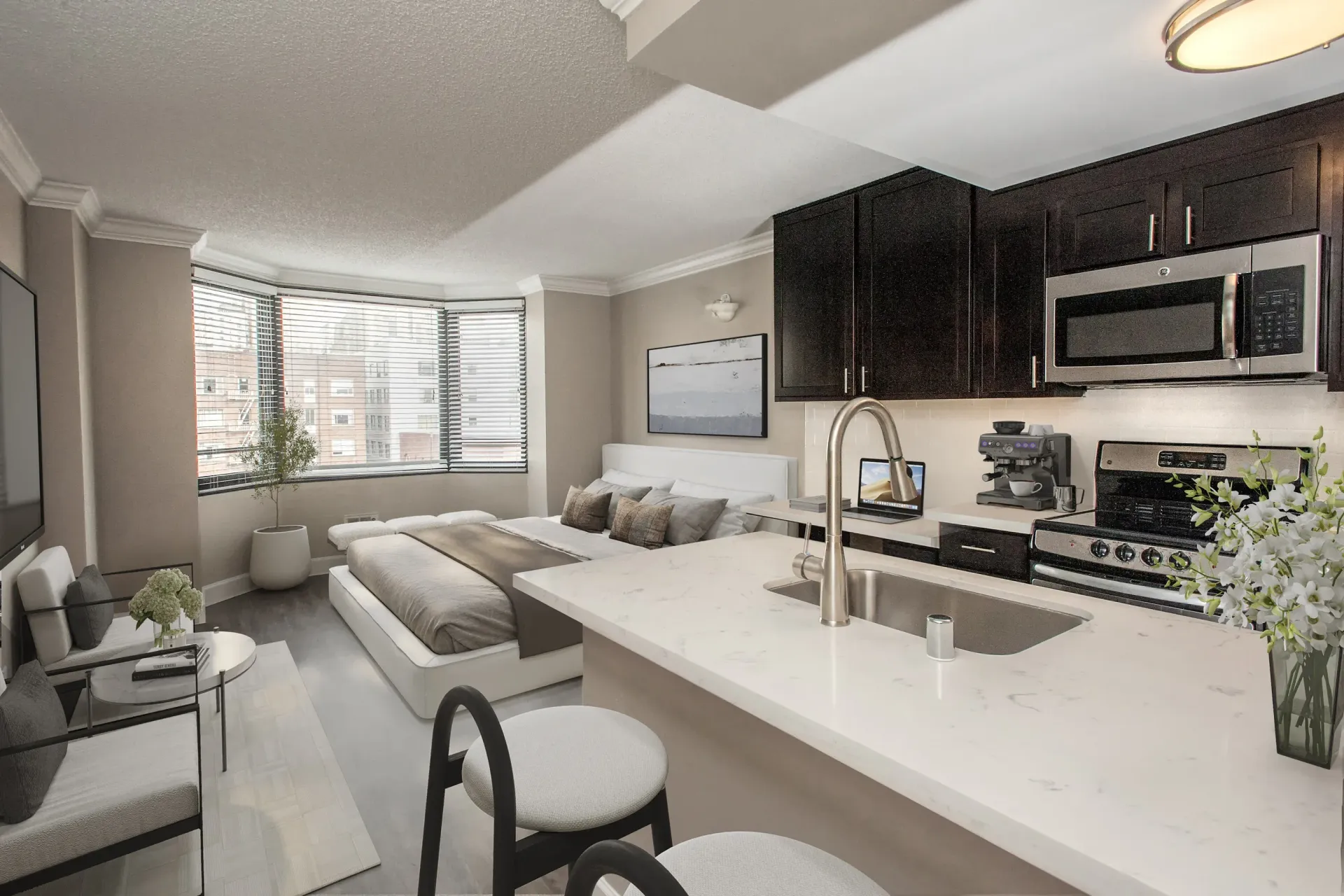 Open-concept apartment interior with a kitchen island, stainless appliances, and a bed in the living area at Tower 737, offering apartments in San Francisco, CA.
