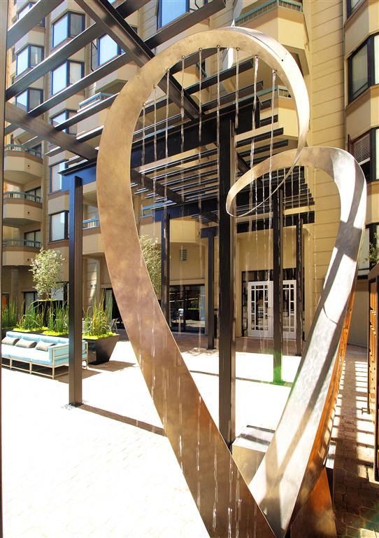Outdoor courtyard with an abstract metal sculpture near the building entrance at Tower 737, offering apartments in San Francisco, CA.