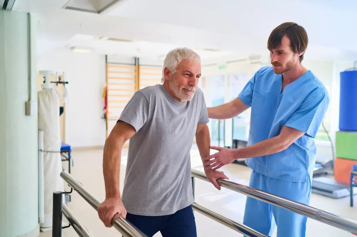 Physical therapist assisting a patient with walking exercises during post-operative rehabilitation