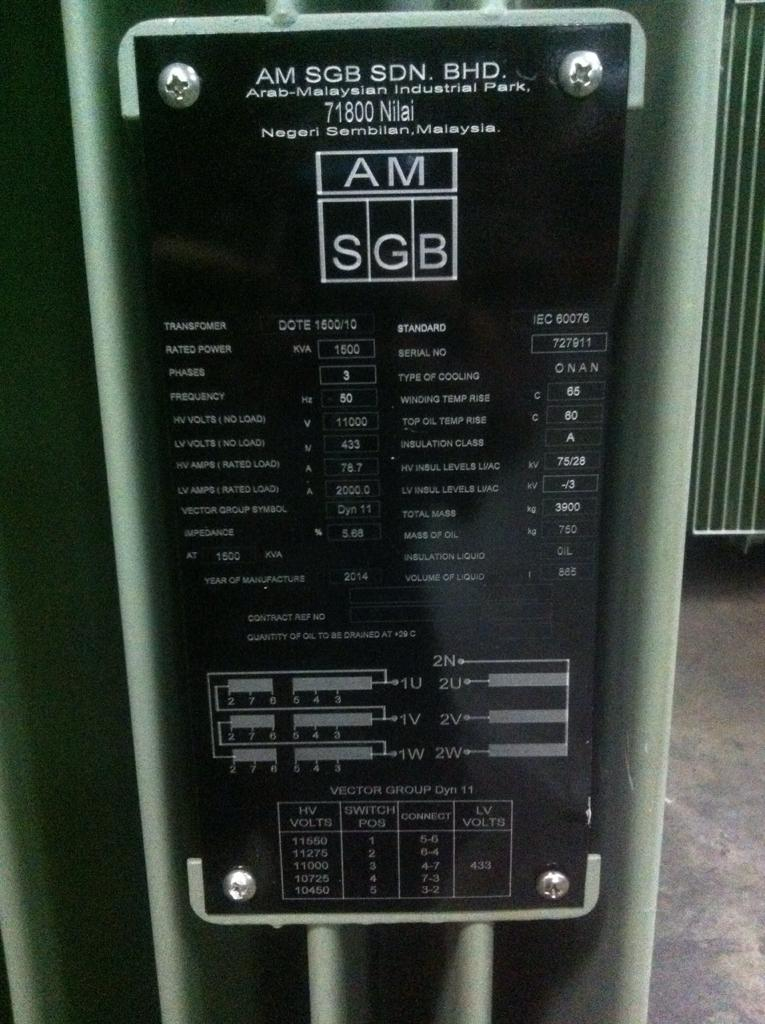 Black label with text and diagrams on green electrical equipment.