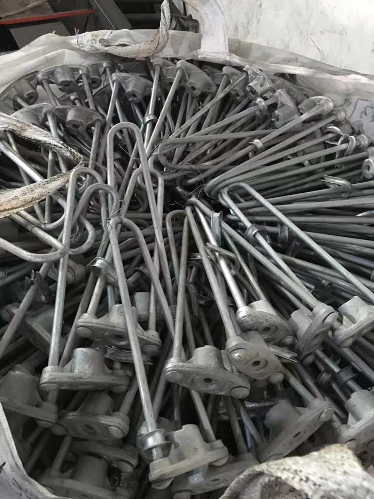 Pile of gray metal parts, likely machinery components, in a white bag.