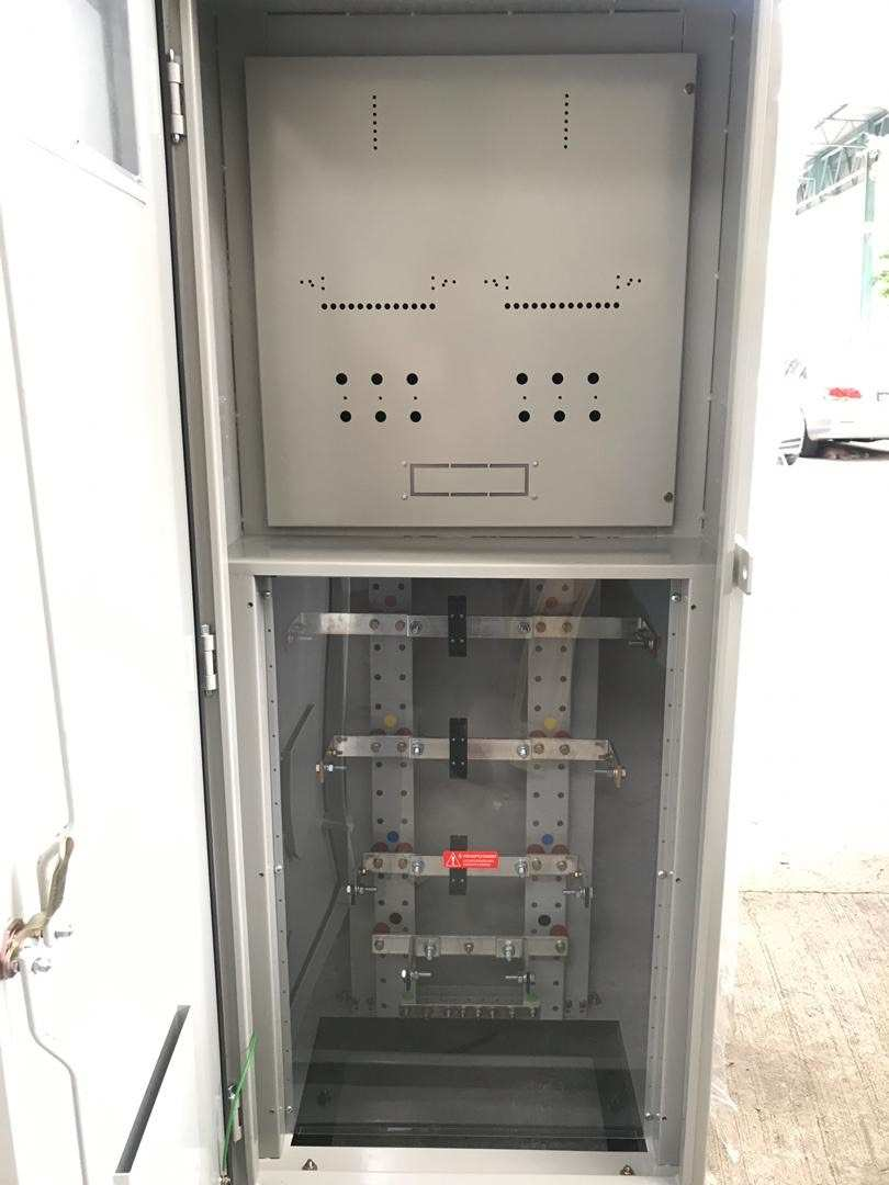 Metal electrical cabinet, gray, open. Interior shows rails and mounting points.