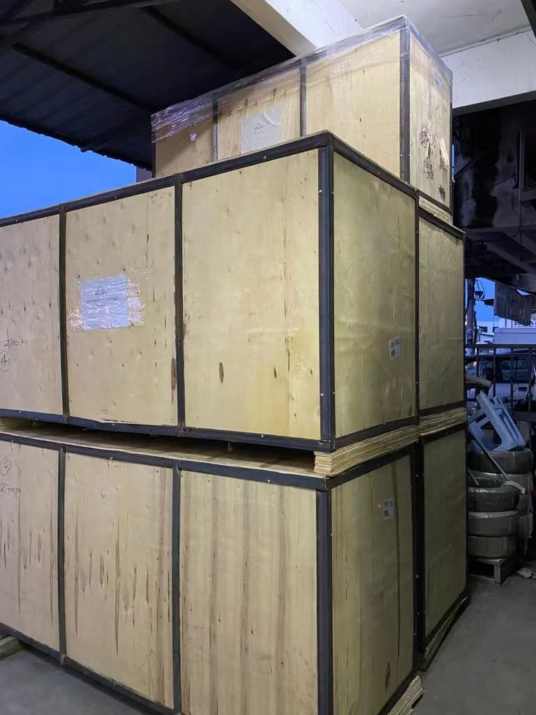 Wooden crates stacked in an industrial setting. Some have metal reinforcement.
