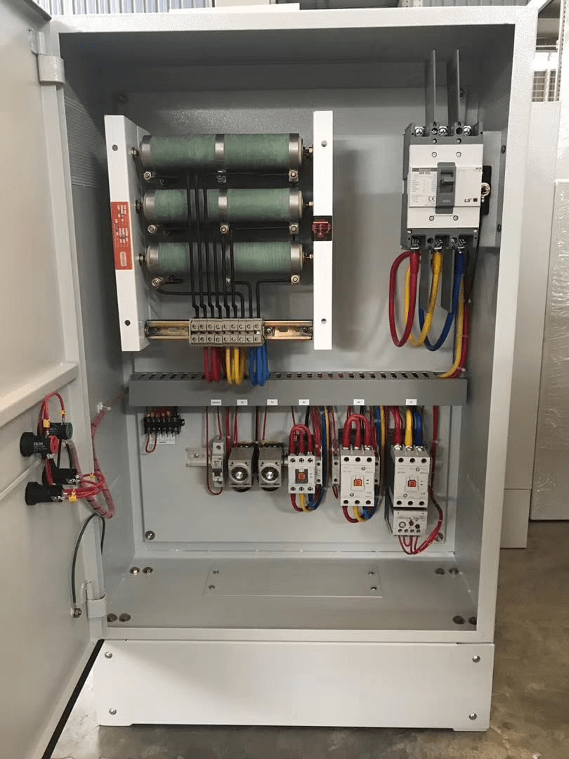 Open electrical cabinet with resistors, circuit breakers, and wiring.