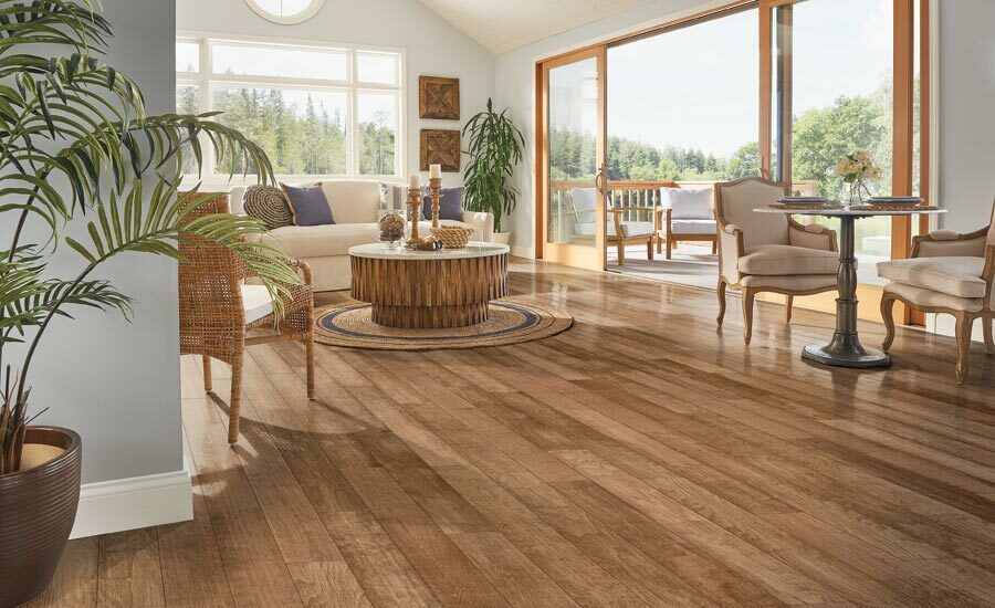 A living room with hardwood floors , a couch , chairs , and a table.