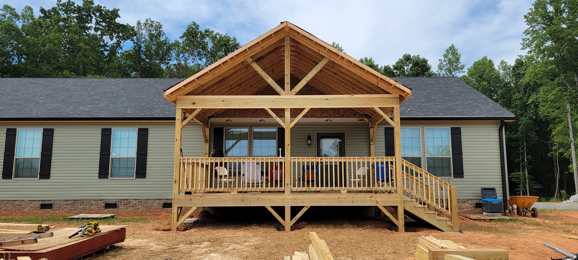 A house with a wooden porch and stairs is being built.