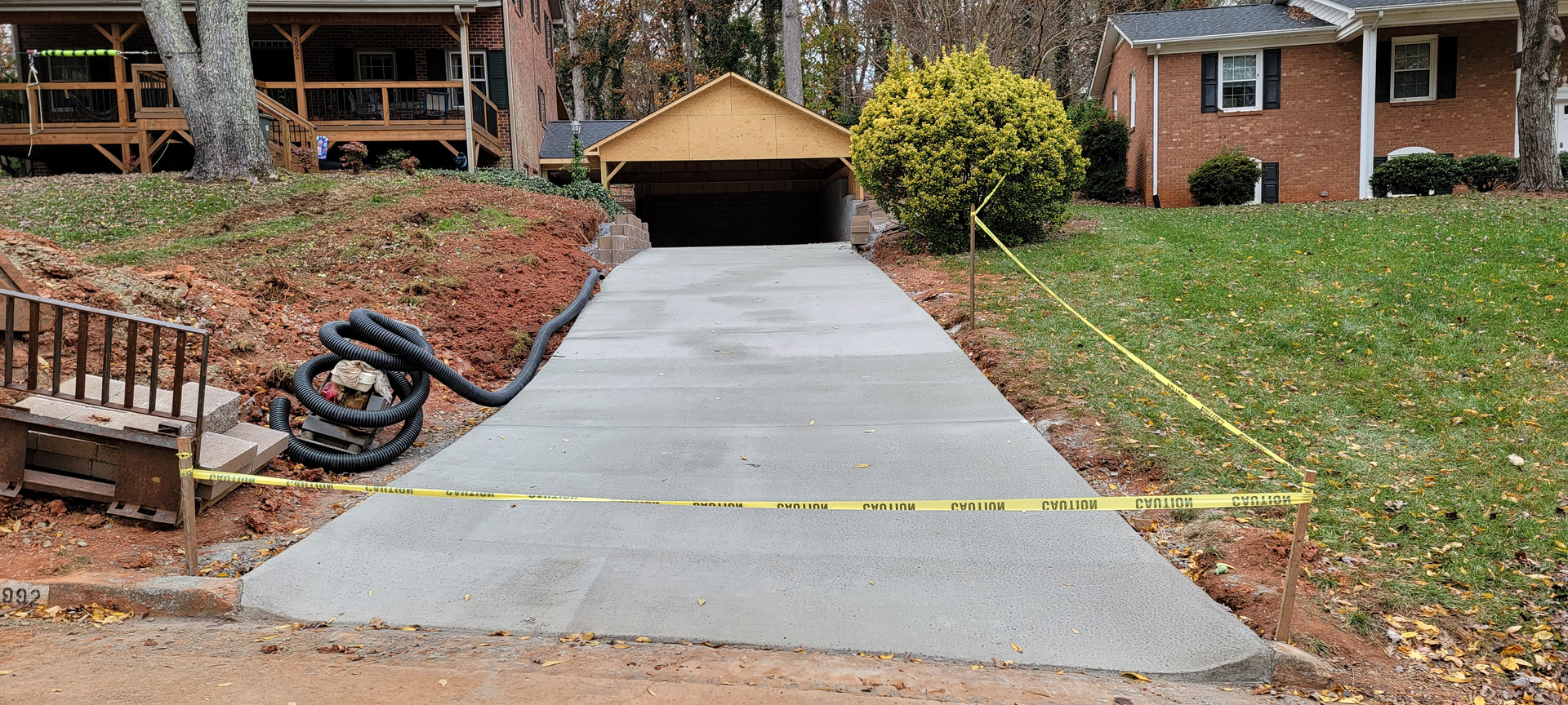 A concrete driveway is being built in front of a house.