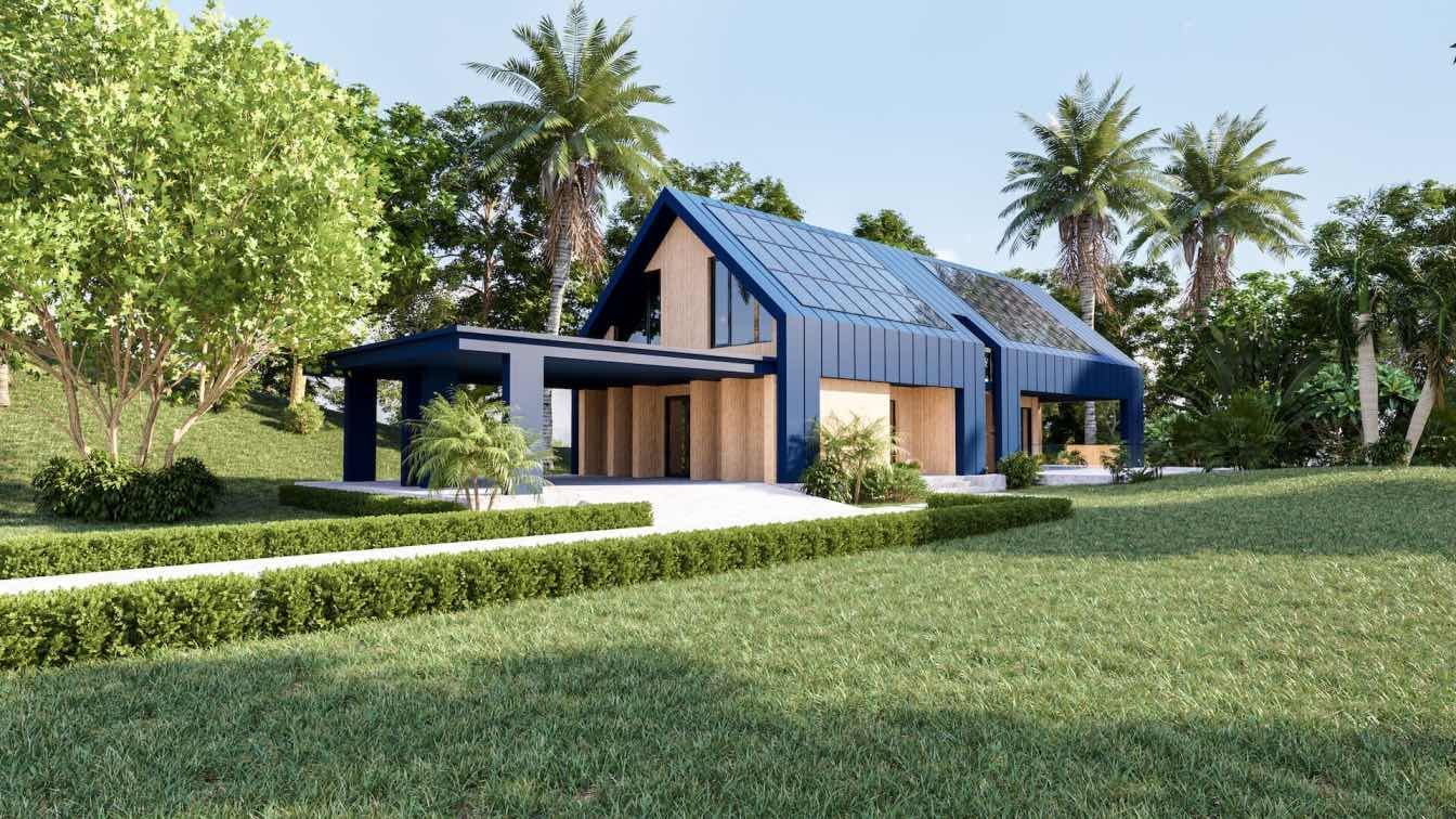 A blue house with a green roof is surrounded by trees and grass.